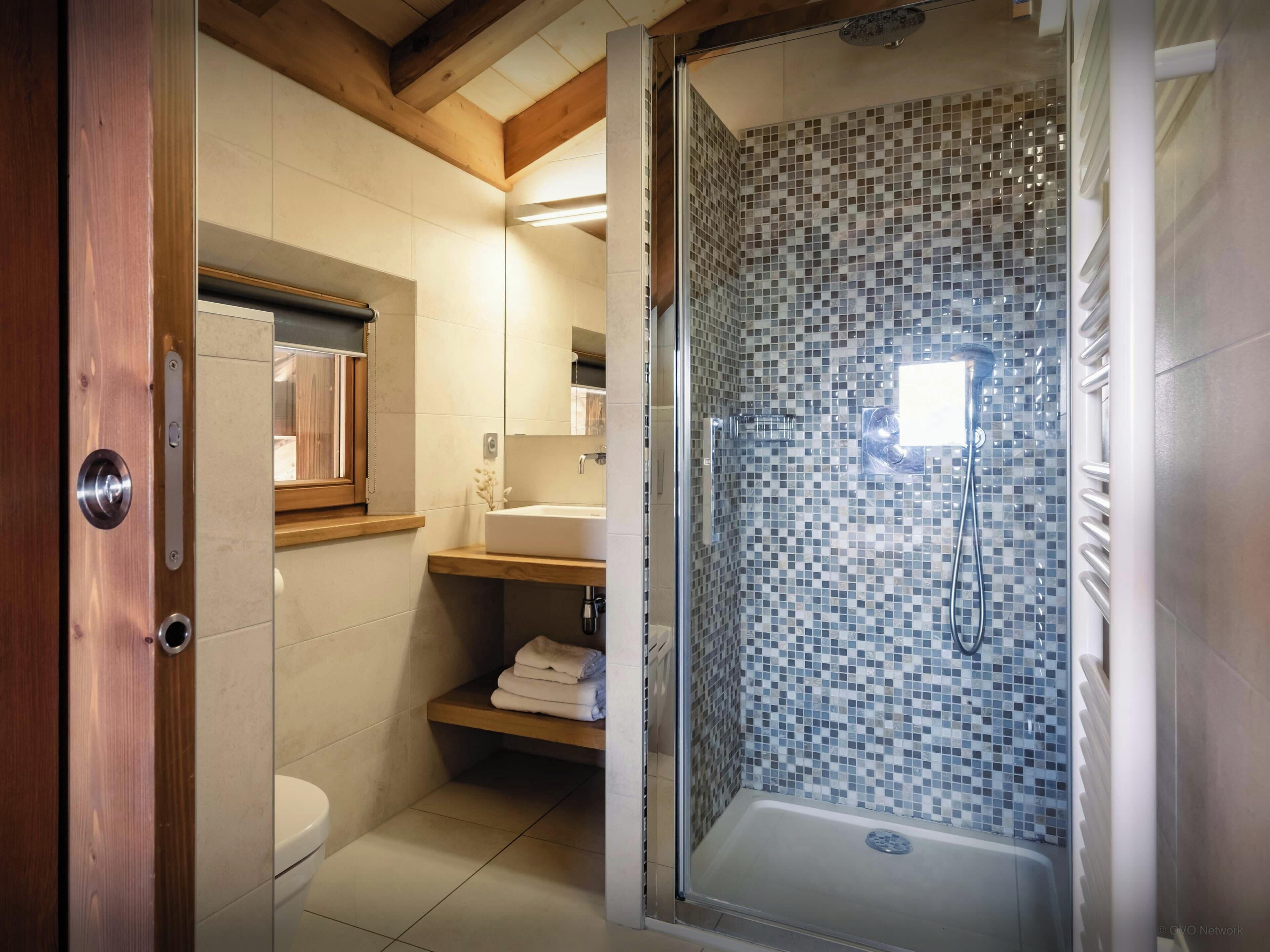 A bathroom with a shower, toilet, and sink.