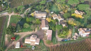 Vista aérea de una zona rural con una casa grande rodeada de campos y edificios más pequeños.