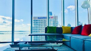 A modern living room with a large window overlooking a cityscape and water. - Amazing apartment Miami Brickell with spectacular views  (Miami)