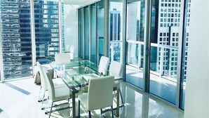 A modern conference room with a glass table and white chairs, large windows offering city views. - Amazing apartment Miami Brickell with spectacular views  (Miami)