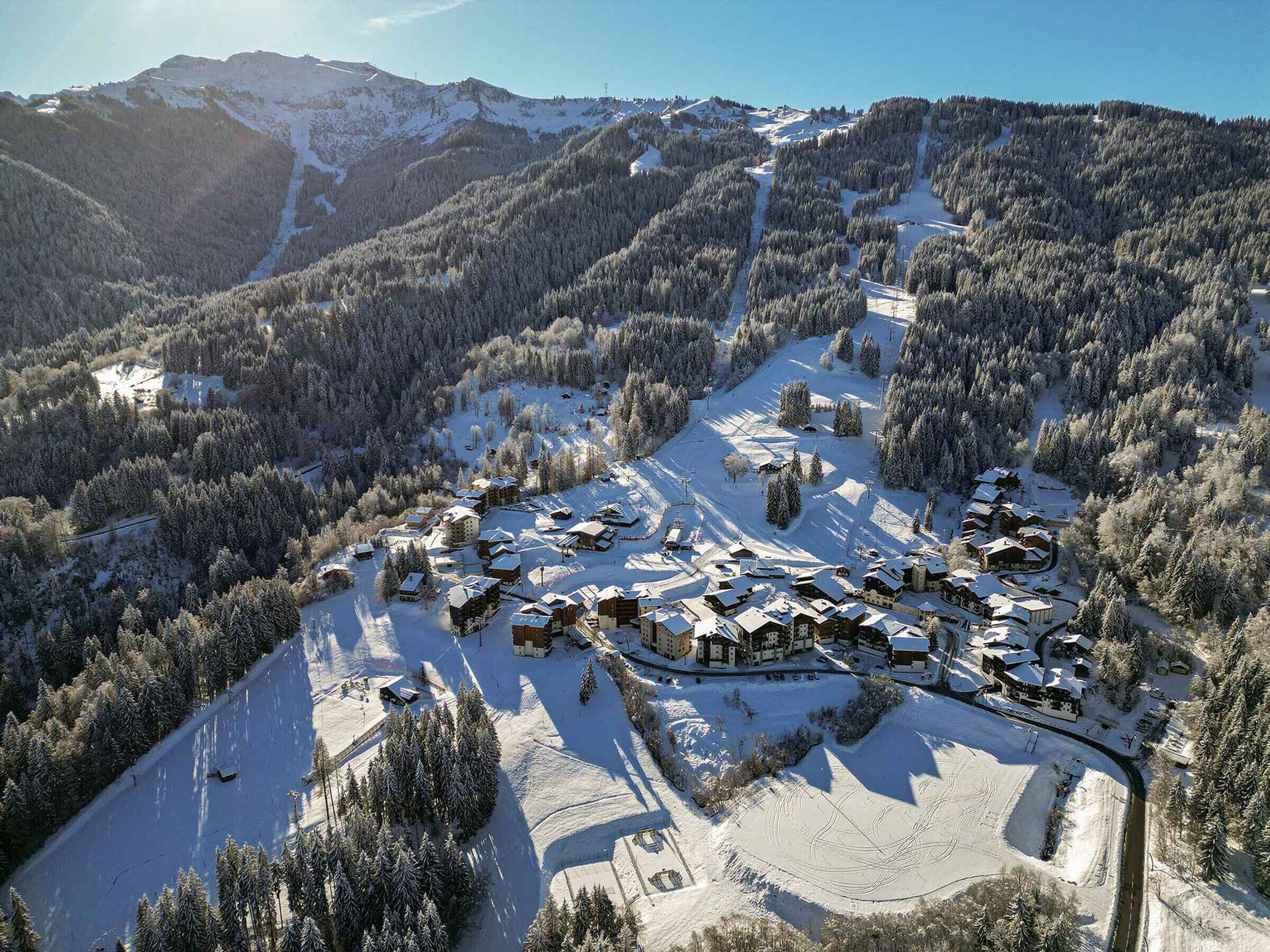 A snow-covered ski resort with multiple lodges and a ski slope.