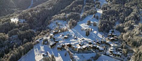 A snow-covered ski resort with multiple lodges and a ski slope.