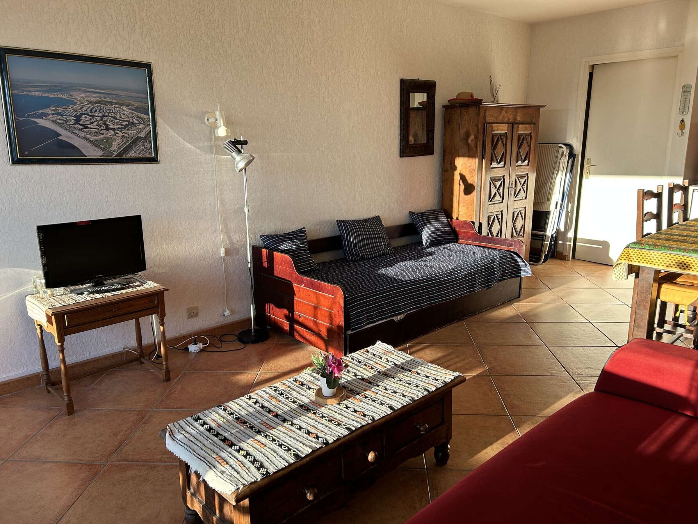 A living room with a sofa, a coffee table, a TV, and a cabinet.
