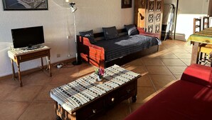 Un salon comprenant un canapé, une table basse, un téléviseur et un meuble.