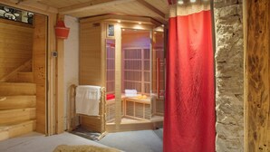 Een houten cabin met een sauna, een houten trap en een rood gordijn.