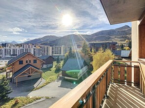 En balkon med udsigt over et boligområde, med huse og et stort kompleks af bygninger.