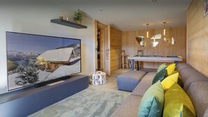 A modern living room with a flat-screen TV, a pool table, and a cozy seating area with cushions. - Chalet Chocolat - Manigod ski base for 8, log fire nights - OVO Network (Manigod)
