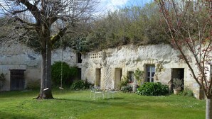 A rustic stone building with multiple windows and a grassy yard. - Charming house with private garden, fireplace and WIFI (Seuilly)