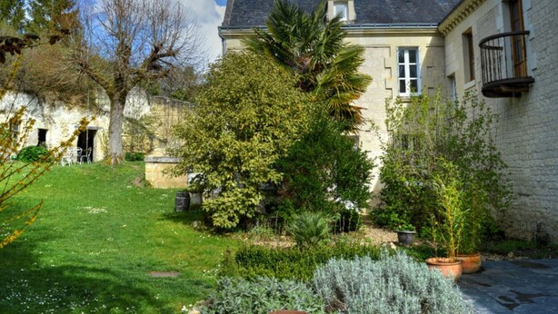 A stone building with a garden, a tree, and a small balcony. - Charming house with private garden, fireplace and WIFI (Seuilly)
