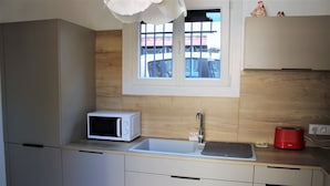 Una cocina moderna con microondas, fregadero y tostadora.
