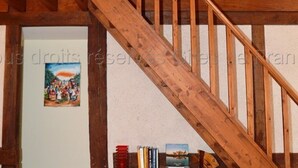 Una escalera de madera con barandilla que lleva a un piso superior.