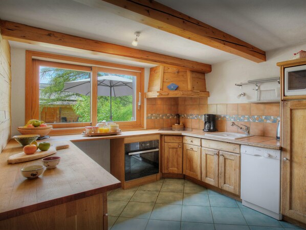 A kitchen with wooden cabinets, a built-in oven, and a window with an umbrella.