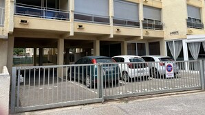 Ein mehrgeschossiges Gebäude mit Parkplatz davor.