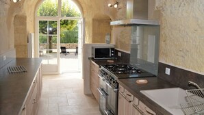 Una cocina moderna con estufa a gas, horno y microondas. Hay un ventanal con vistas al exterior.