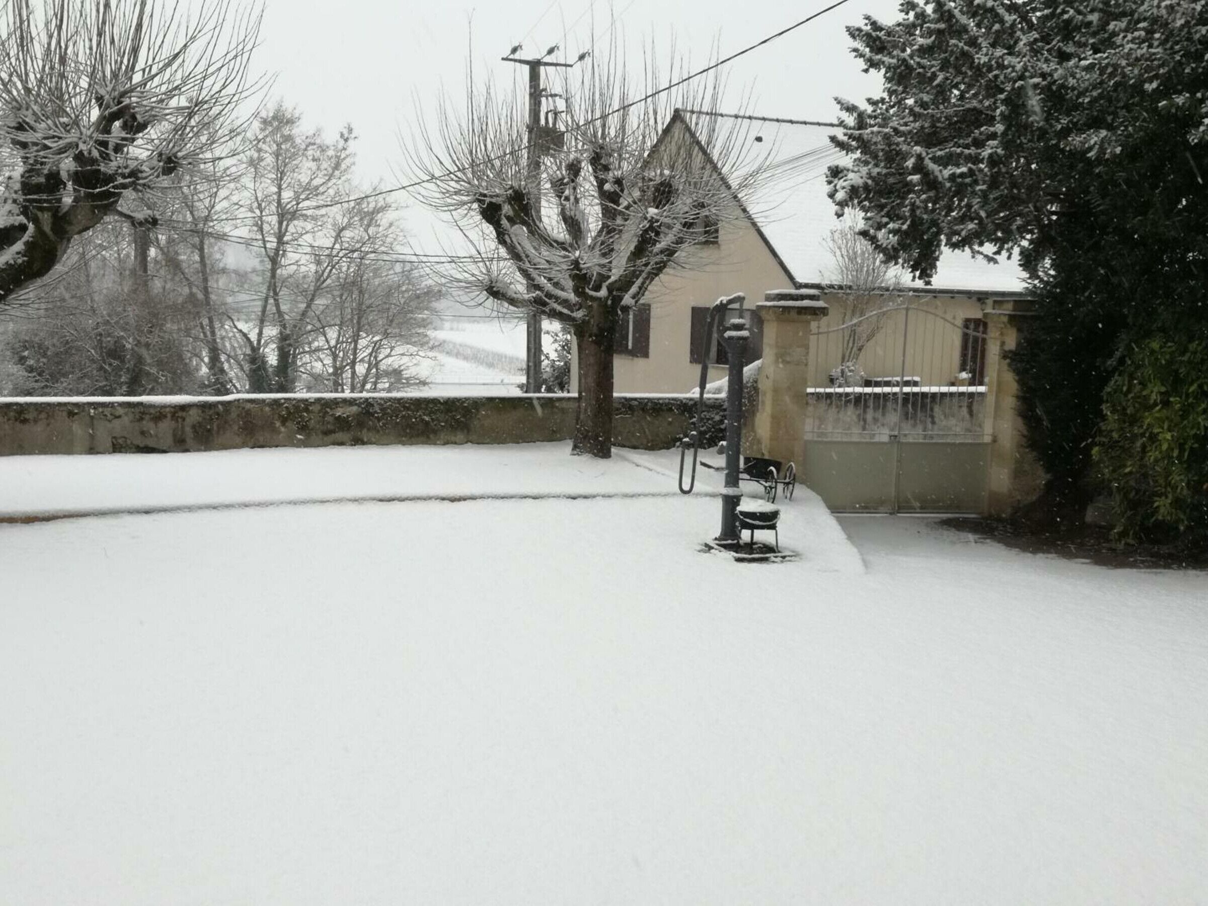 A snow-covered street with a utility pole and a bicycle parked on the sidewalk.