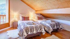 A cozy bedroom with two beds, wooden ceiling, and a large window. - Les Roses des Alpes - luxury mountain break, views & spa - OVO Network (Thônes)
