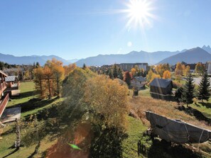 A mountainous landscape with autumn foliage, a clear sky, and a building with a sloped roof. - Bright apartment 35m², 5 pers, south balcony, near slopes, parking, wifi (La Toussuire)