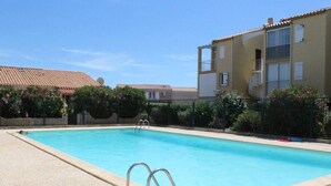 A rectangular swimming pool with a tiled deck, surrounded by a fence and greenery. - Beachside Studio with Mezzanine, Pool, Tennis, 800m to Beach - 4 Guests, Pet-Friendly (Fleury-Saint-Pierre-la-Mer)