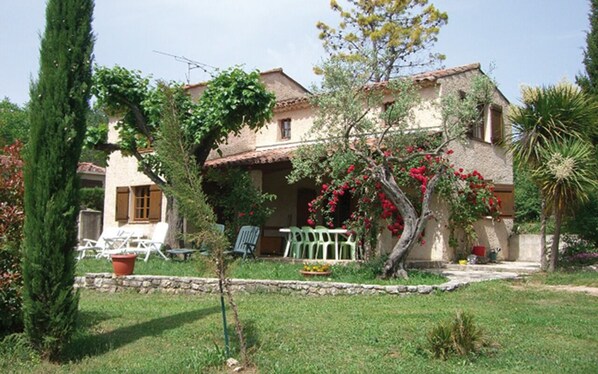 Traditional two-story building with a well-maintained garden and outdoor seating areas.