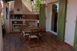 Enjoy al fresco dining in a patio area with a barbecue grill and comfortable seating.