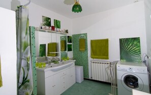 Enjoy a clean and bright bathroom with a vanity, mirror, and shower, plus a convenient laundry area.