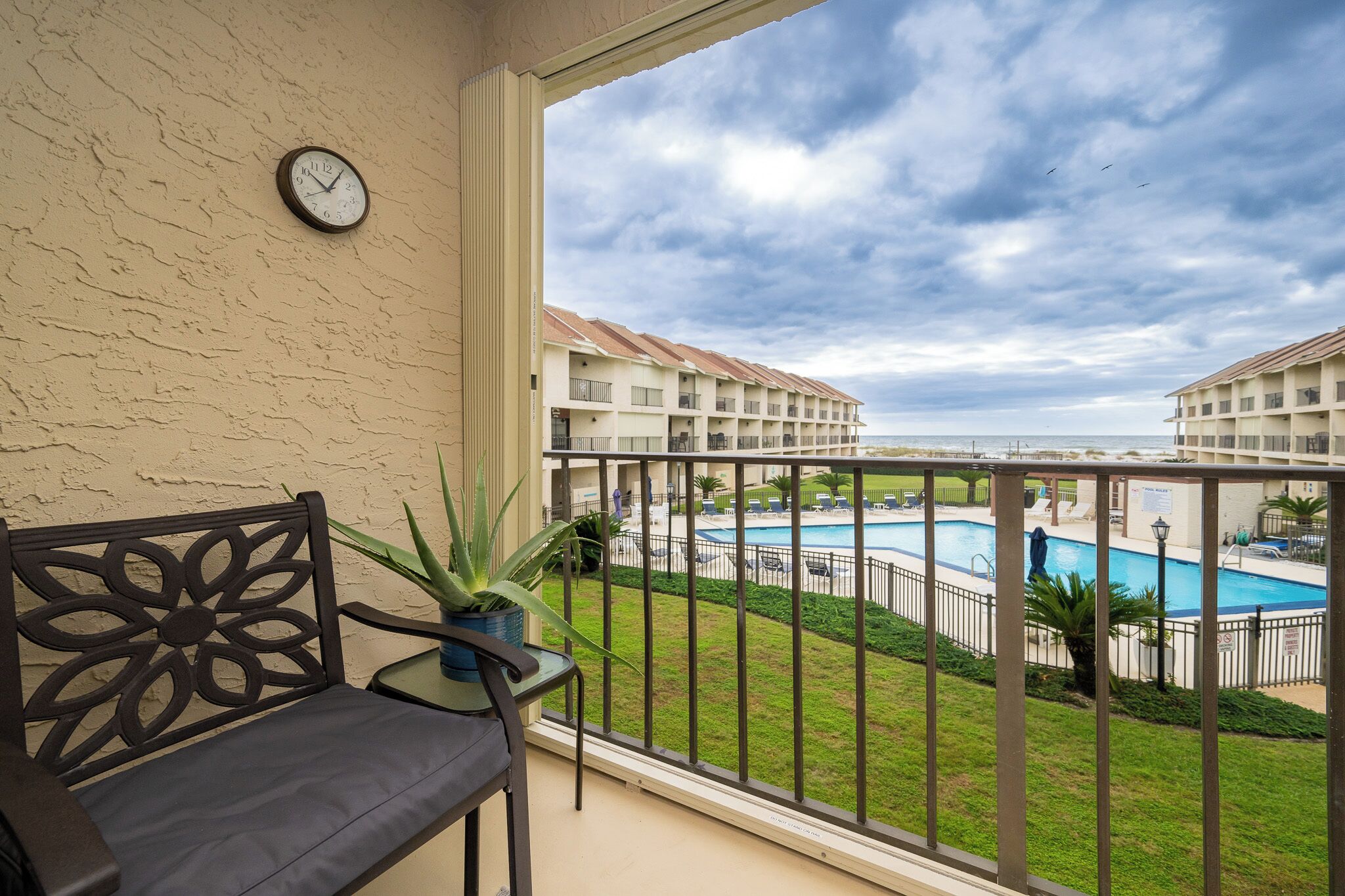 Un balcon donnant sur une piscine et les bâtiments de l’hôtel.
