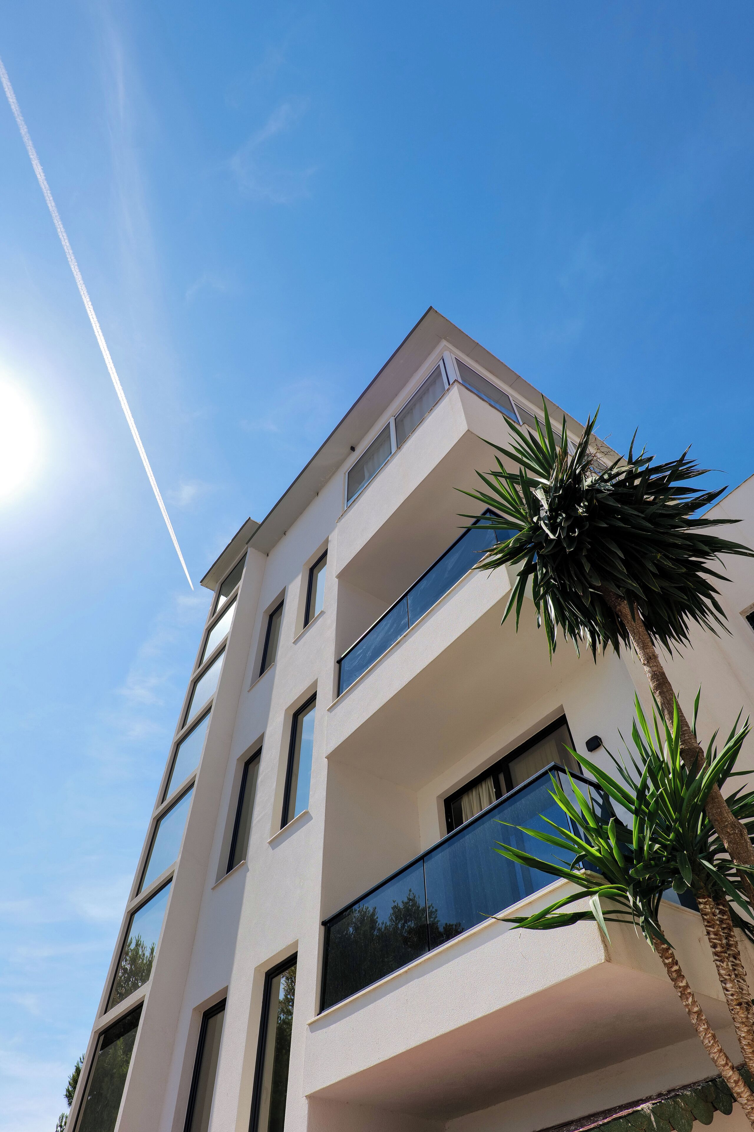 A multi-story building with balconies and large windows.
