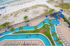 Ein Resort mit Poolbereich, Liegestühlen und Strand.