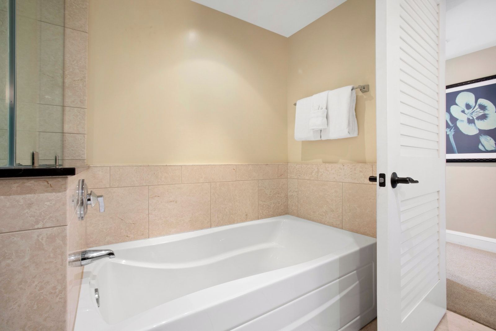 Une salle de bain avec une baignoire, un miroir et un porte-serviettes.