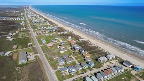 An aerial view of a coastal residential area with houses, a beach, and a road. - Heavenly Sunset...A House With Amazing Views And Just Steps From The Beach (Surfside Beach)
