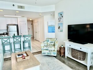 Relax in this stylish living space with a comfortable seating area, flat-screen TV, and modern kitchen.