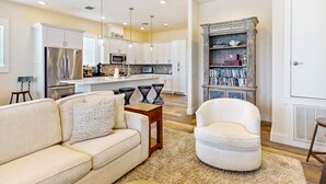 A modern kitchen with white cabinets, stainless steel appliances, and pendant lighting. - Luxe Palmilla Beach Resort house with pool, dining & private golf cart (Port Aransas)