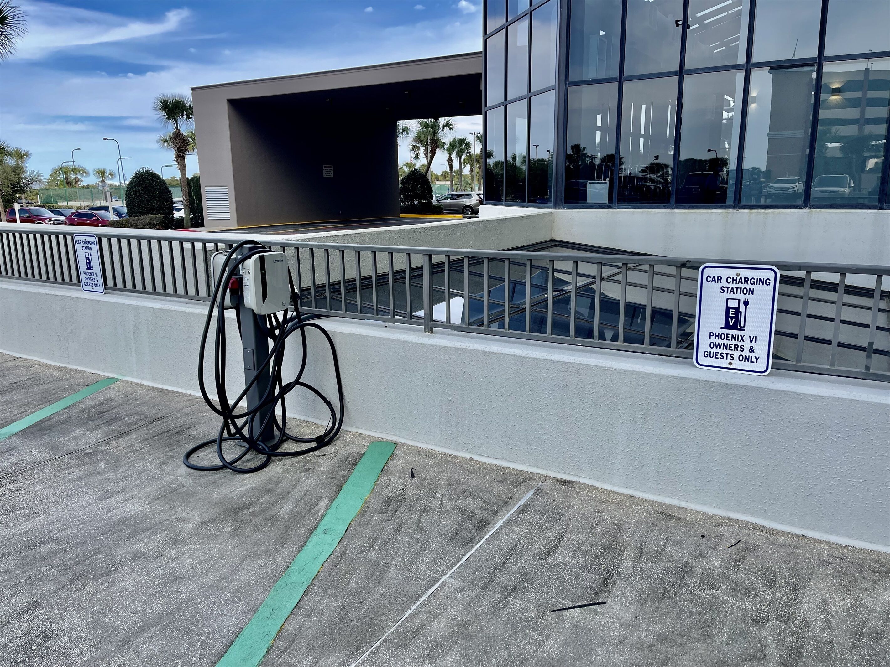 A car charging station with a sign indicating it's for Phoenix VI owners and guests only.