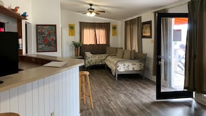 A cozy living room with a sofa, a wooden coffee table, and a ceiling fan.