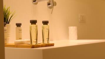 A bathroom with a white sink, two Tuscan Soul scented bottles, and a wooden tray.