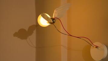Eine Wandleuchte mit Glühbirne und rotem Kabel.