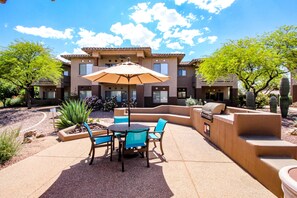 Relax in style on this patio, complete with a round table and comfortable seating for four.