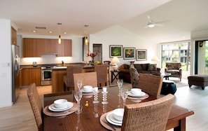 A modern kitchen with wooden cabinets, stainless steel appliances, and pendant lighting. - Spacious Modern Haven Just Steps from the Beach - Wailea Elua #908 -Lush Grounds (Wailea, Maui)