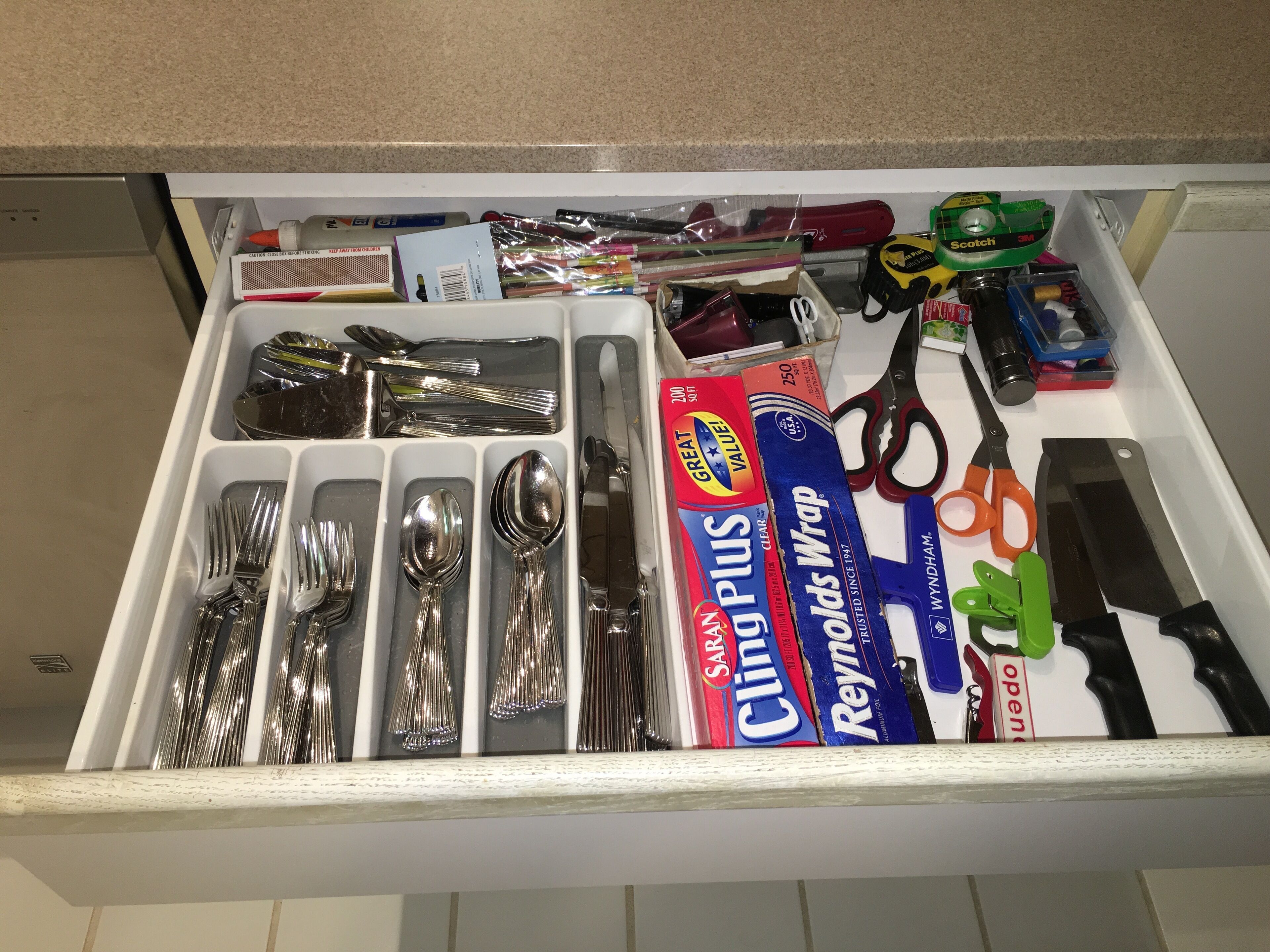 A drawer with neatly organized kitchen utensils, including forks, spoons, and a box of Clorox wipes.