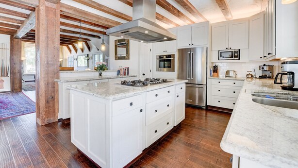 Una cocina moderna con armarios blancos, electrodomésticos de acero inoxidable y una isla grande.