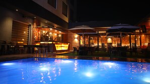 Un espace piscine extérieur avec un bar et des sièges.