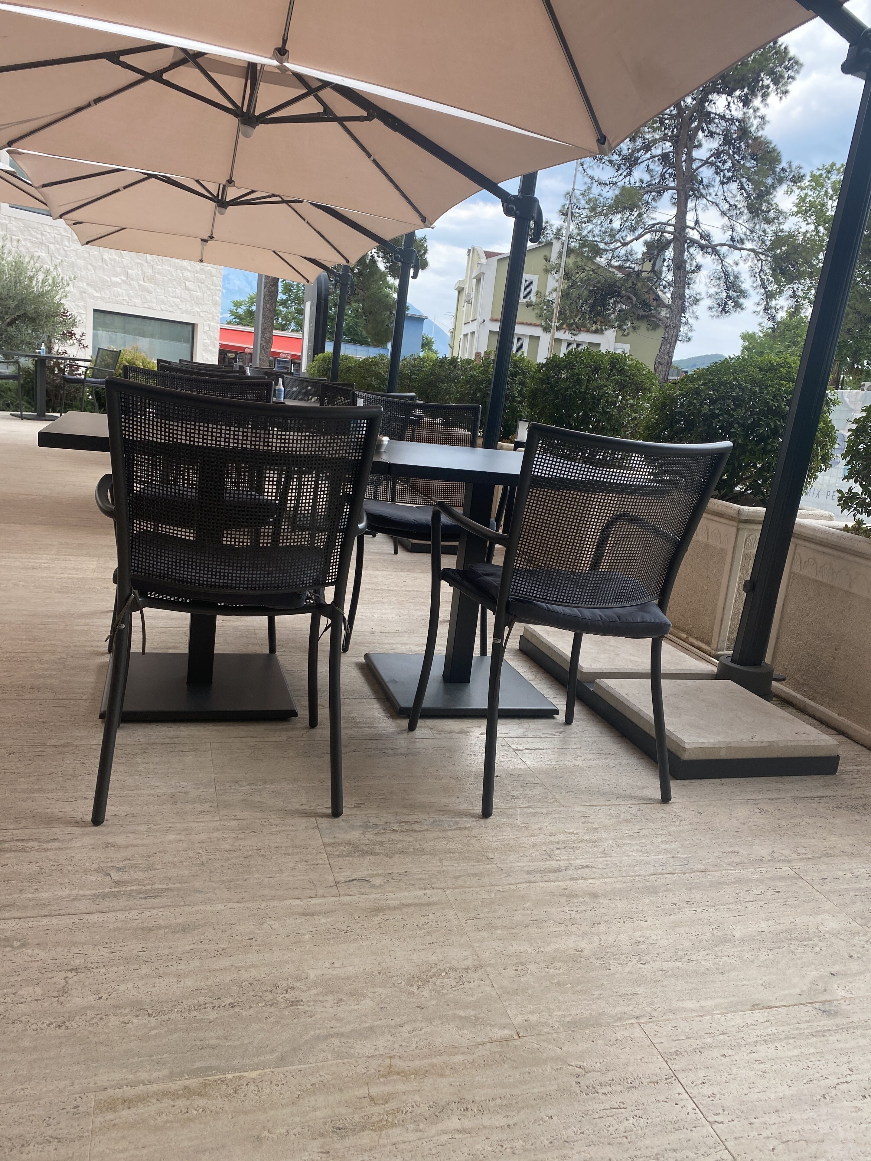 Outdoor seating with tables and chairs under a canopy.