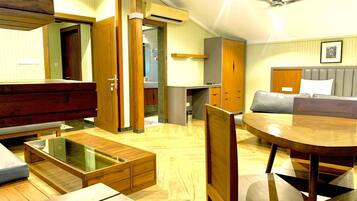 A spacious living area with a wooden coffee table, a round dining table, and a sofa.