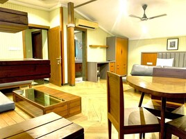 Un amplio salón con una mesa de centro de madera, una mesa de comedor redonda y un sofá.
