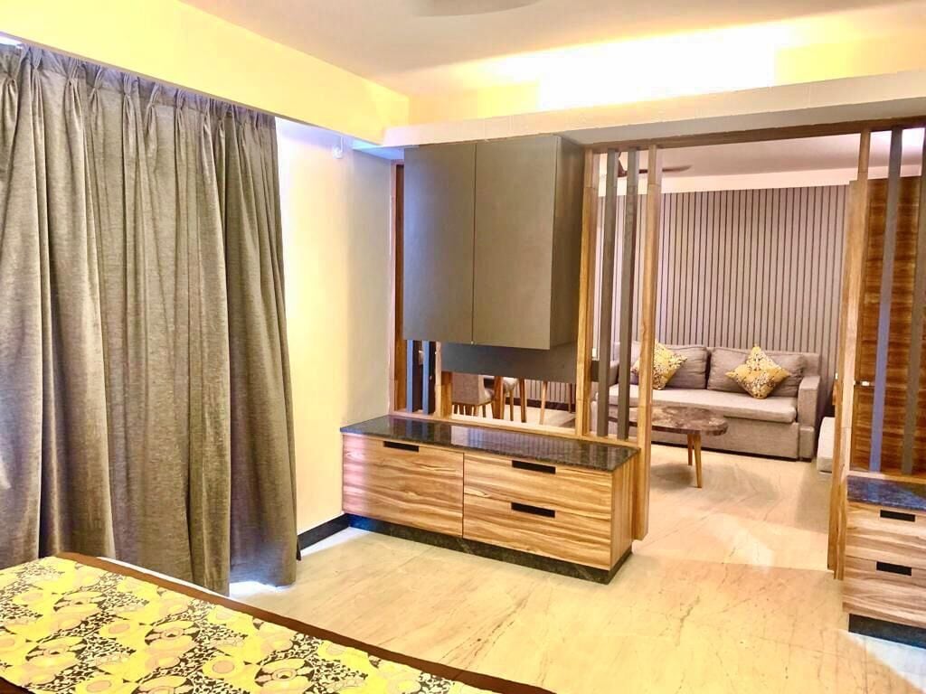 Una sala moderna con un mueble de madera, un sofá y un televisor.