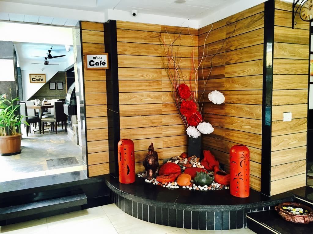 A reception area with a wooden wall, a clock, and a sign that reads "11th Floor Café".