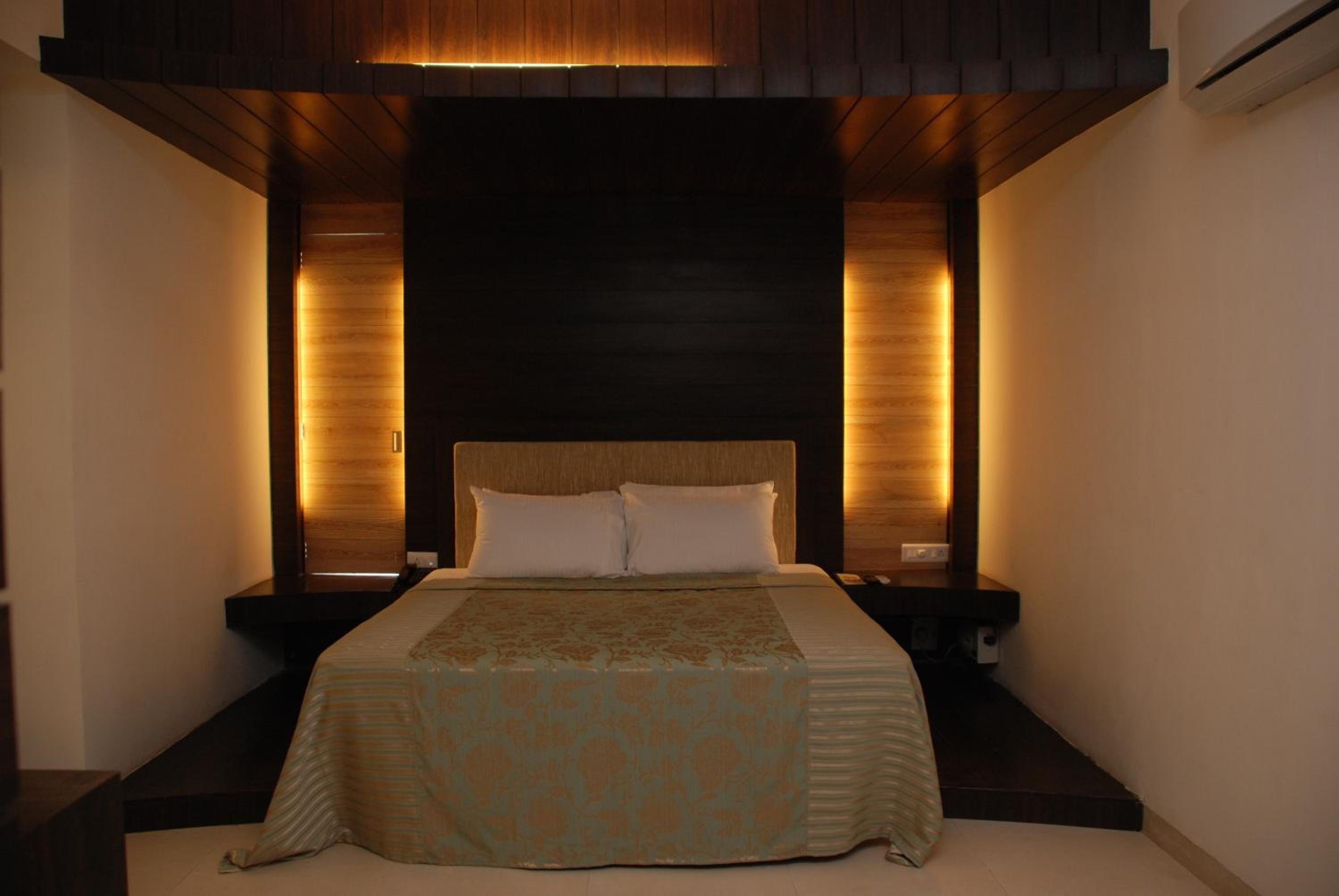 Ein Schlafzimmer mit einem großen Bett, einem Holz-Kopfteil und Nachttischen.