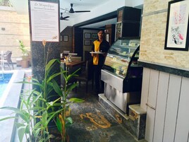 Restaurante com área na piscina, um cardápio e um balcão com alimentos.