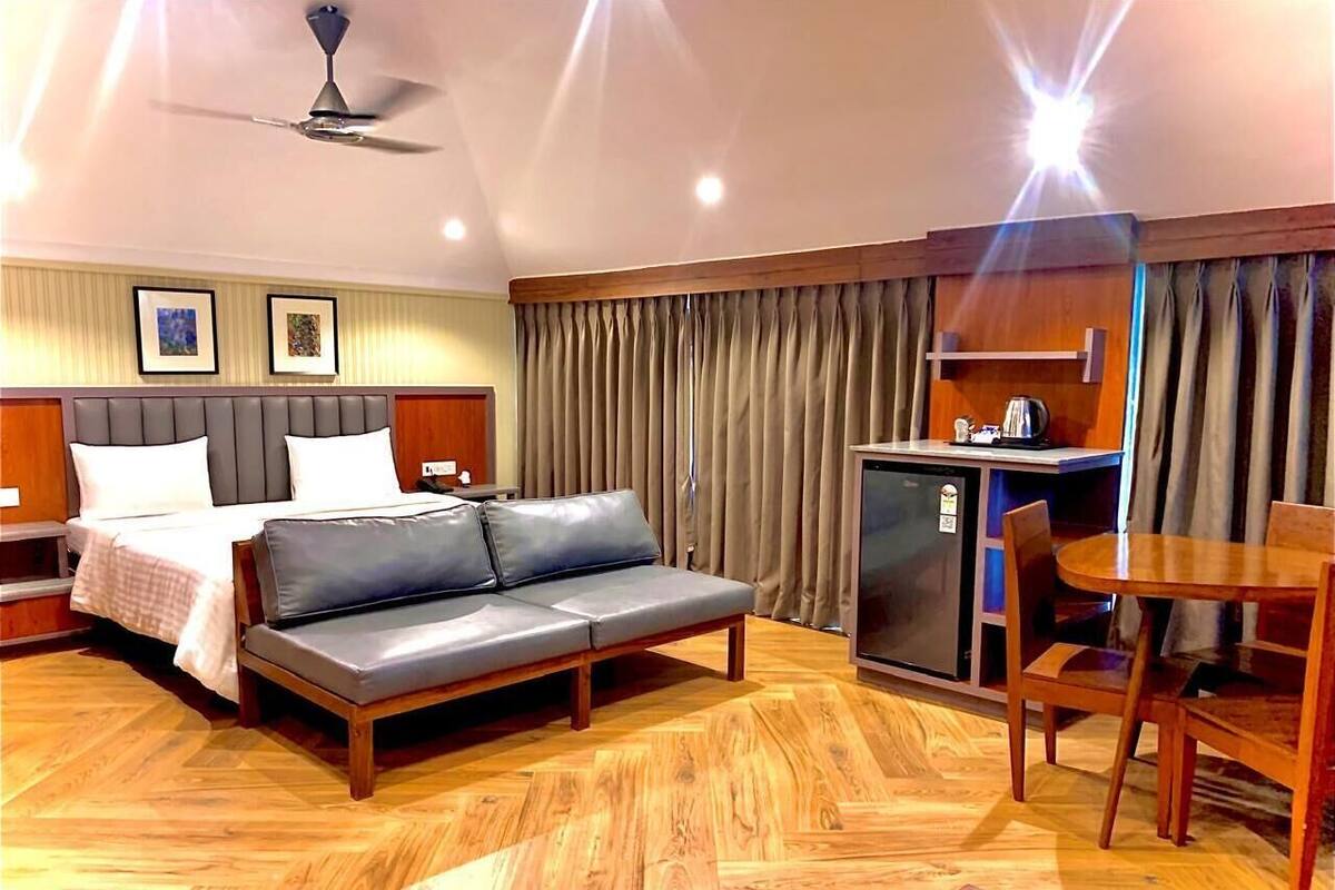 Une chambre d’hôtel comprenant un lit, un canapé, une table à manger et une kitchenette.