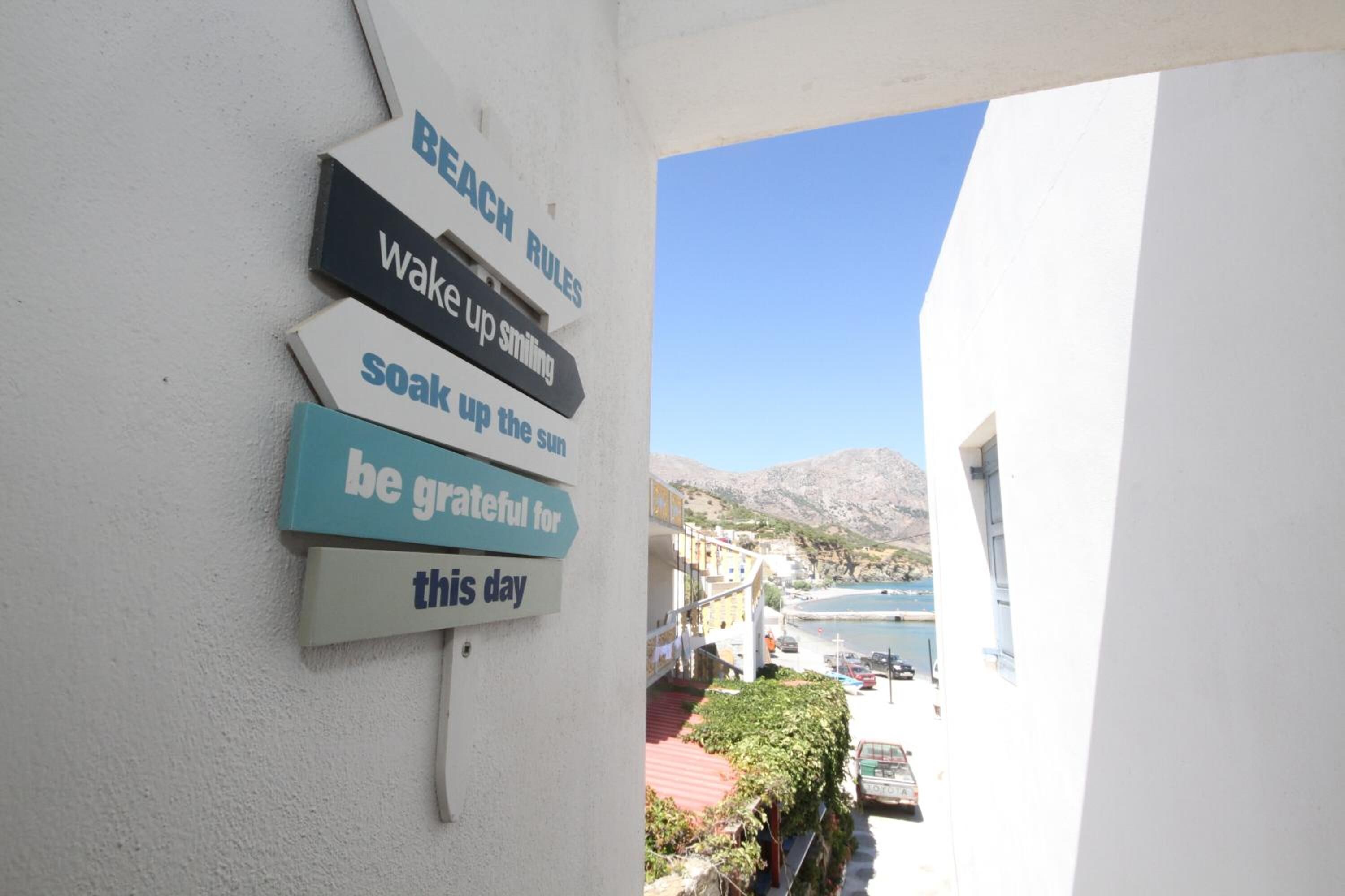 A wall with motivational signs and a view of a coastal area with buildings and a mountain in the background.